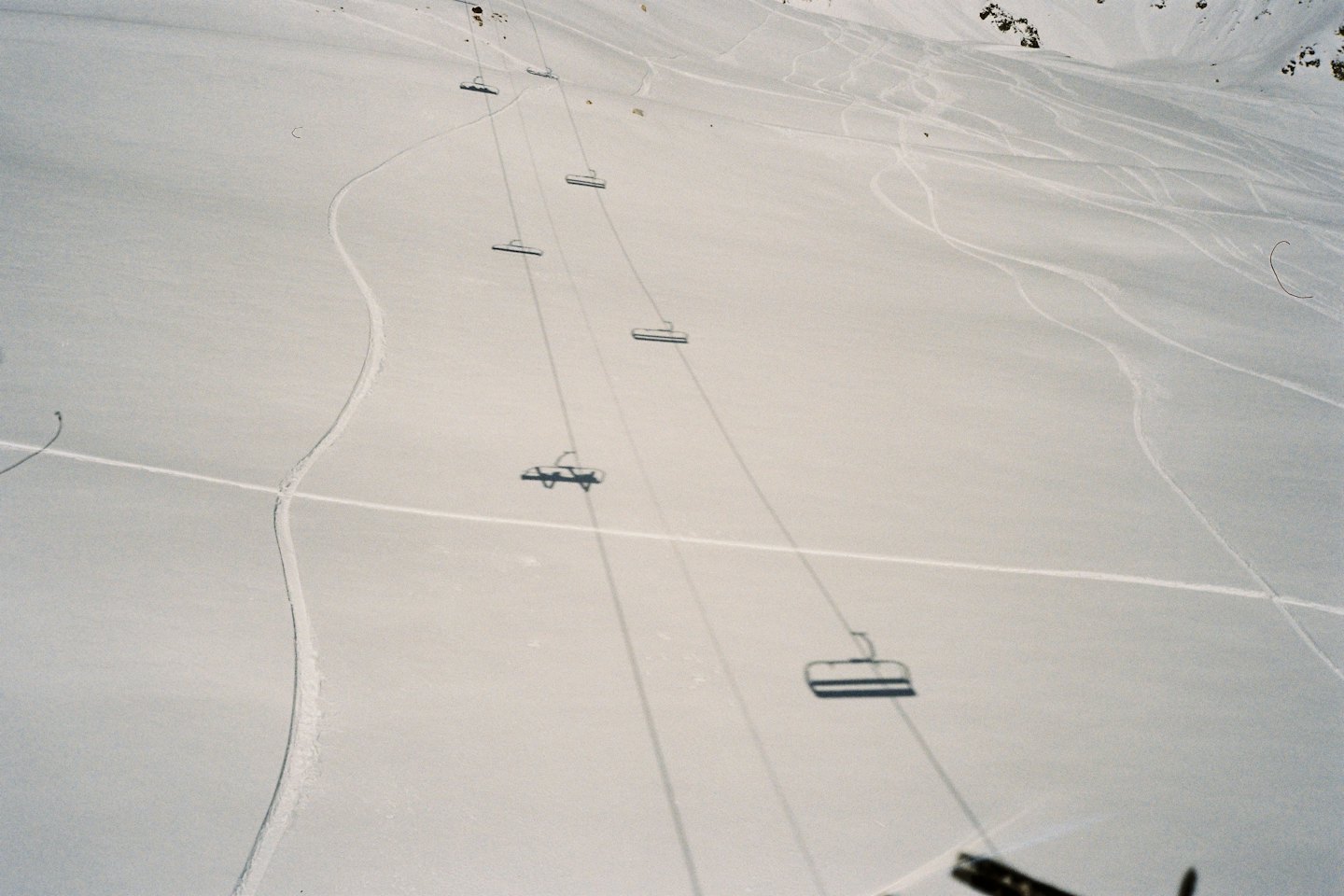Le seggiovie scivolano su un pendio montano innevato.